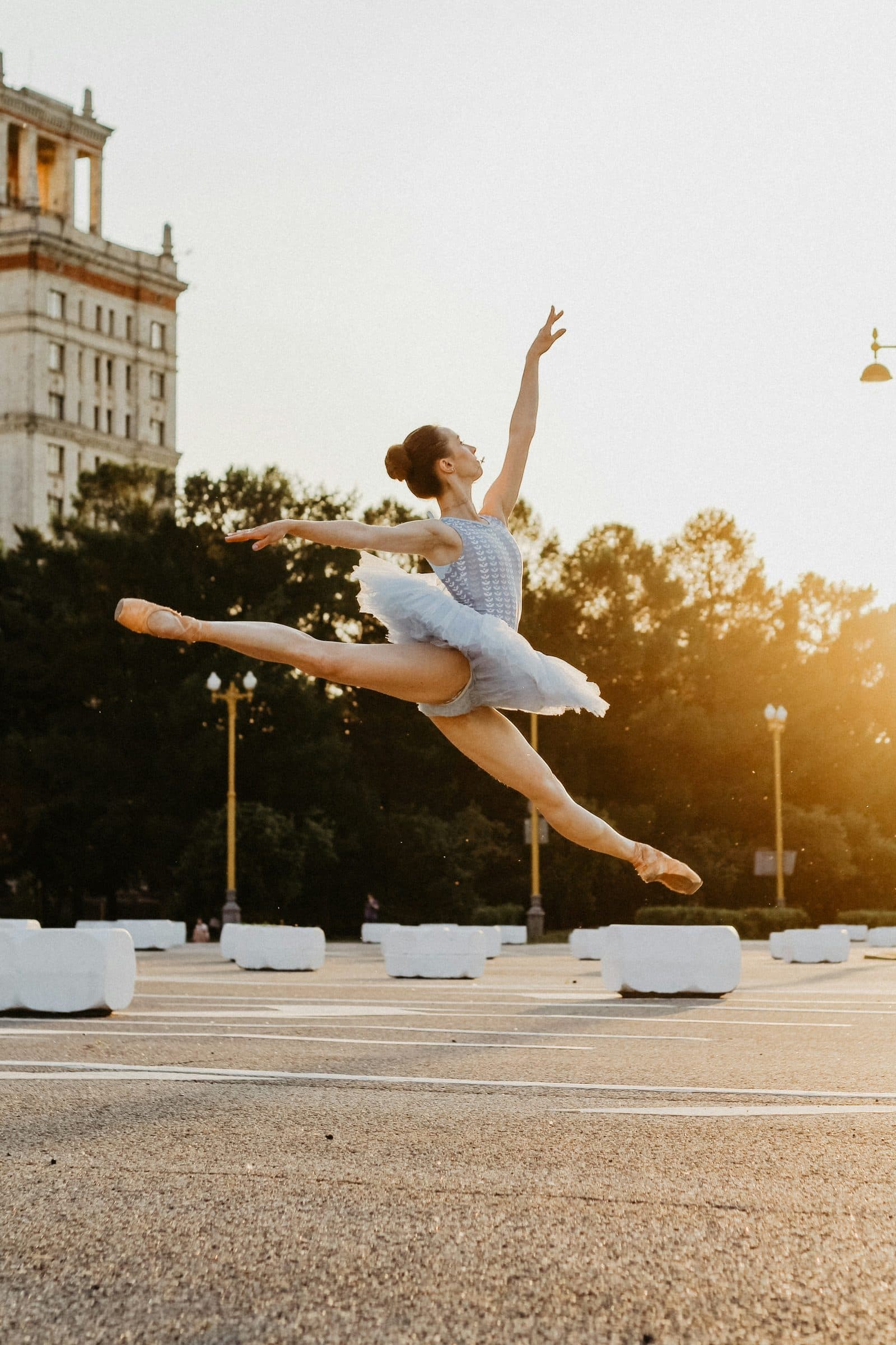 A dancer at full extension in mid-air, en pointe, in morning light